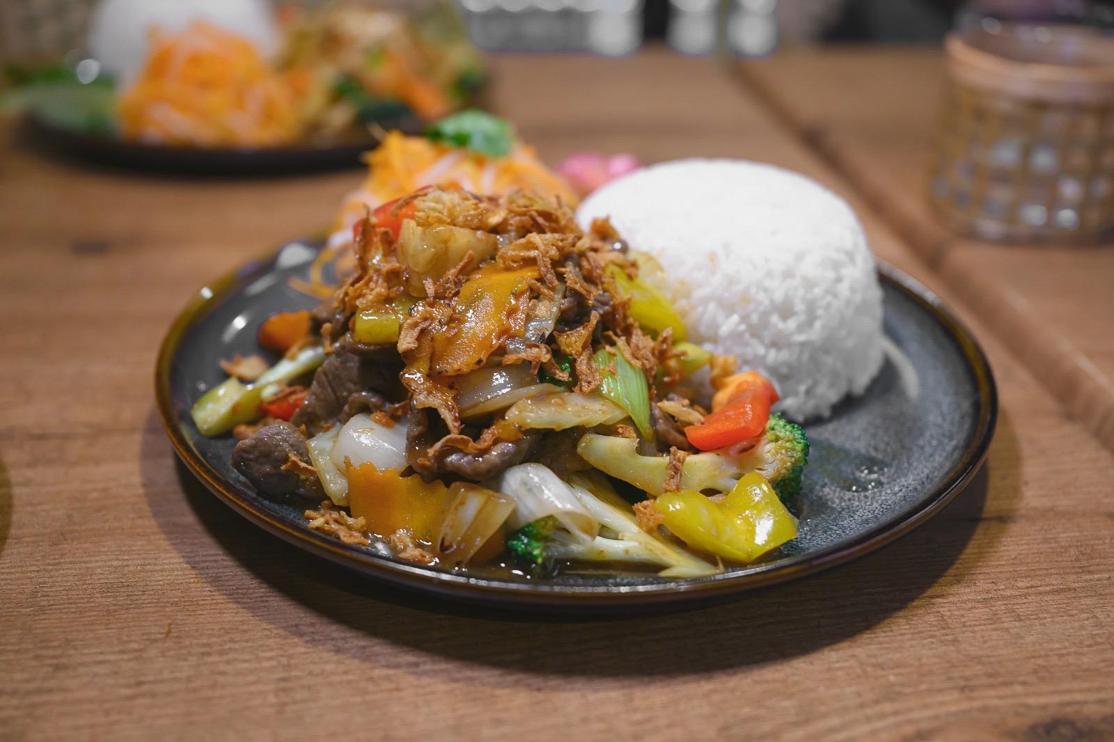 Wok-fired beef with peppers and Thai basil in a dark bowl