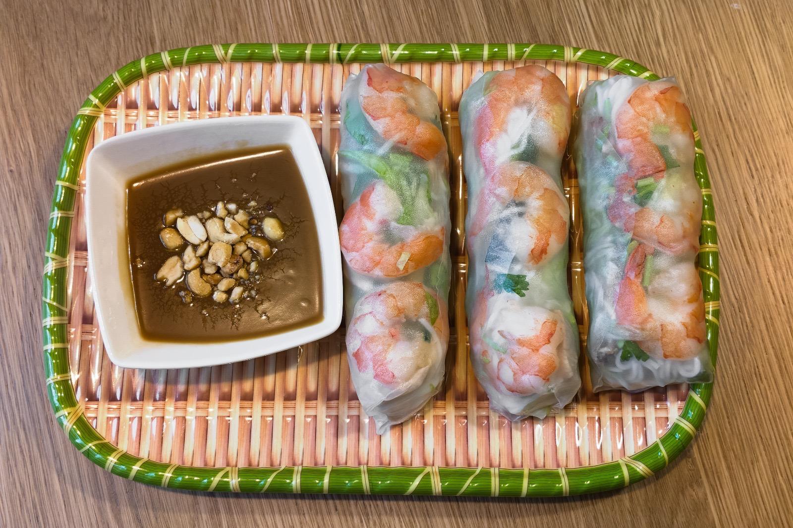 Gỏi cuốn — fresh rice paper rolls with prawns, pork and herbs on a black plate